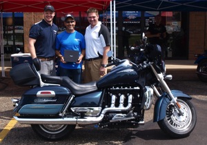 Photo (left to right): Chase Rose (left) and Carl Peshoff (right) of Northern Ohio Triumph present John Viscomi (center) with the Triumph Rocket III Touring motorcycle he won in a nationwide sweepstakes. The motorcycle has $2,000 in custom audio equipment from Southern California’s Al & Ed’s Autosound.